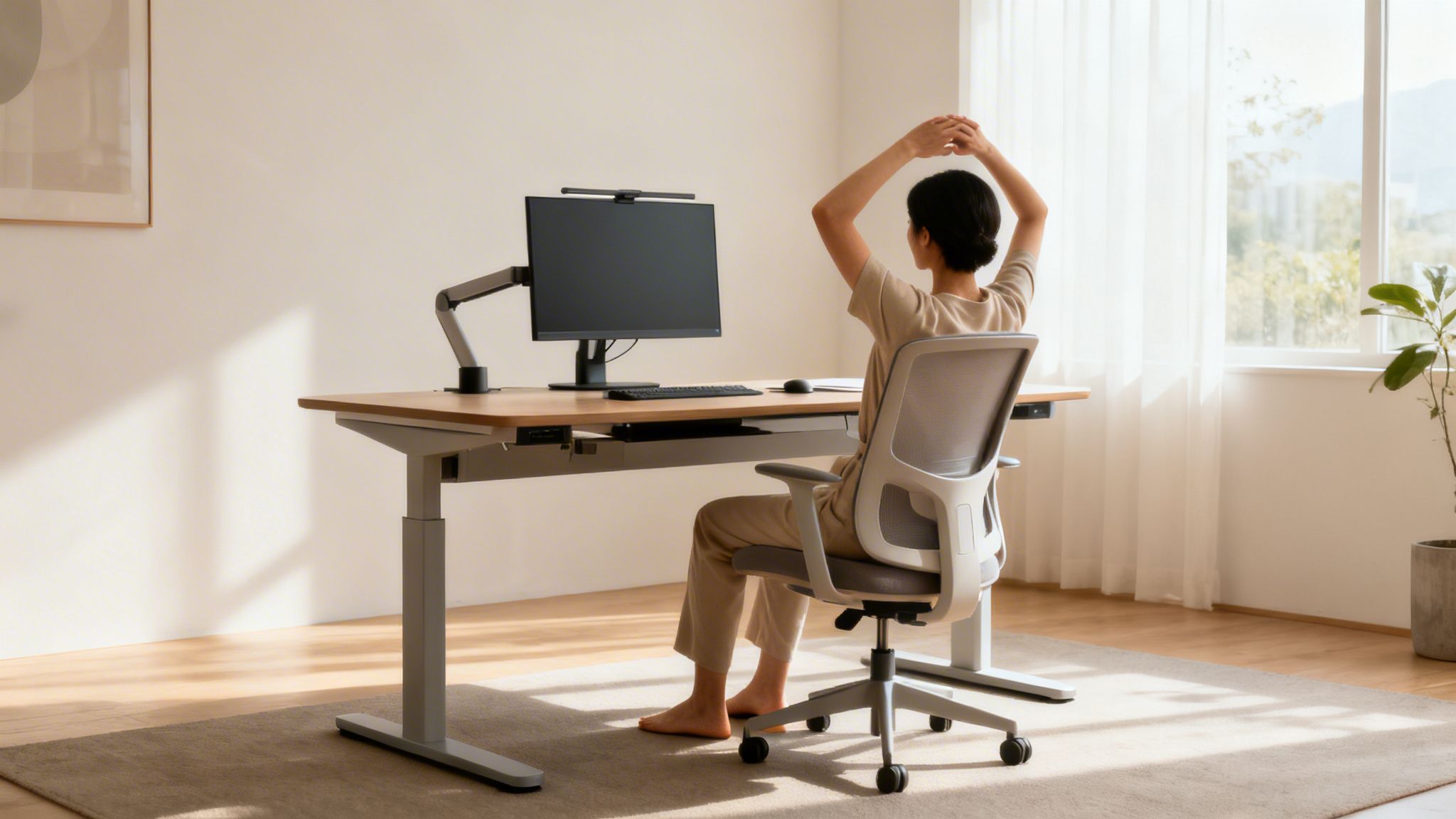 Kvinde strækker sig ved et moderne skrivebord med computerskærm og ergonomisk stol i et lyst hjemmekontor.
